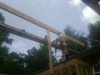 Carpenter setting a ridge beam over a new addition frame — Ice Dam Removal by Roofing Brothers in Keswick