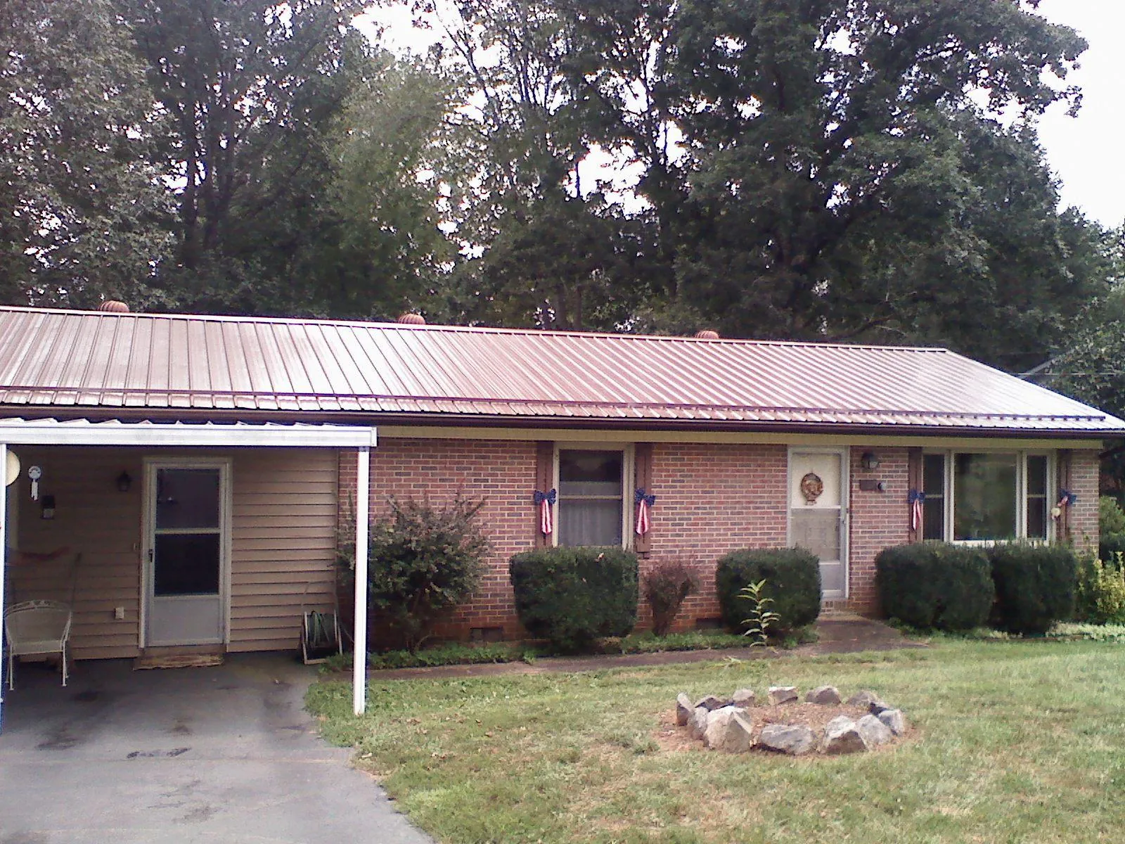 Bronze metal roof and carport on a brick ranch home — Roof Repair work by our crew in Keswick